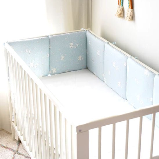 Tour de lit bébé bleu éléphant dans berceau blanc