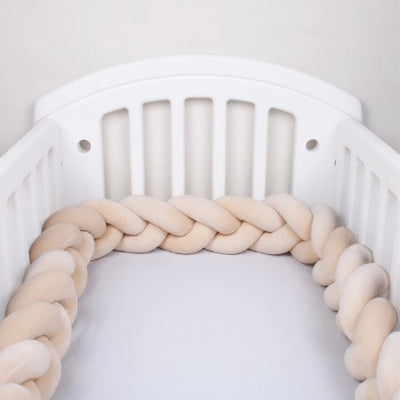Tresse de lit cocon sécurisé beige dans un berceau blanc